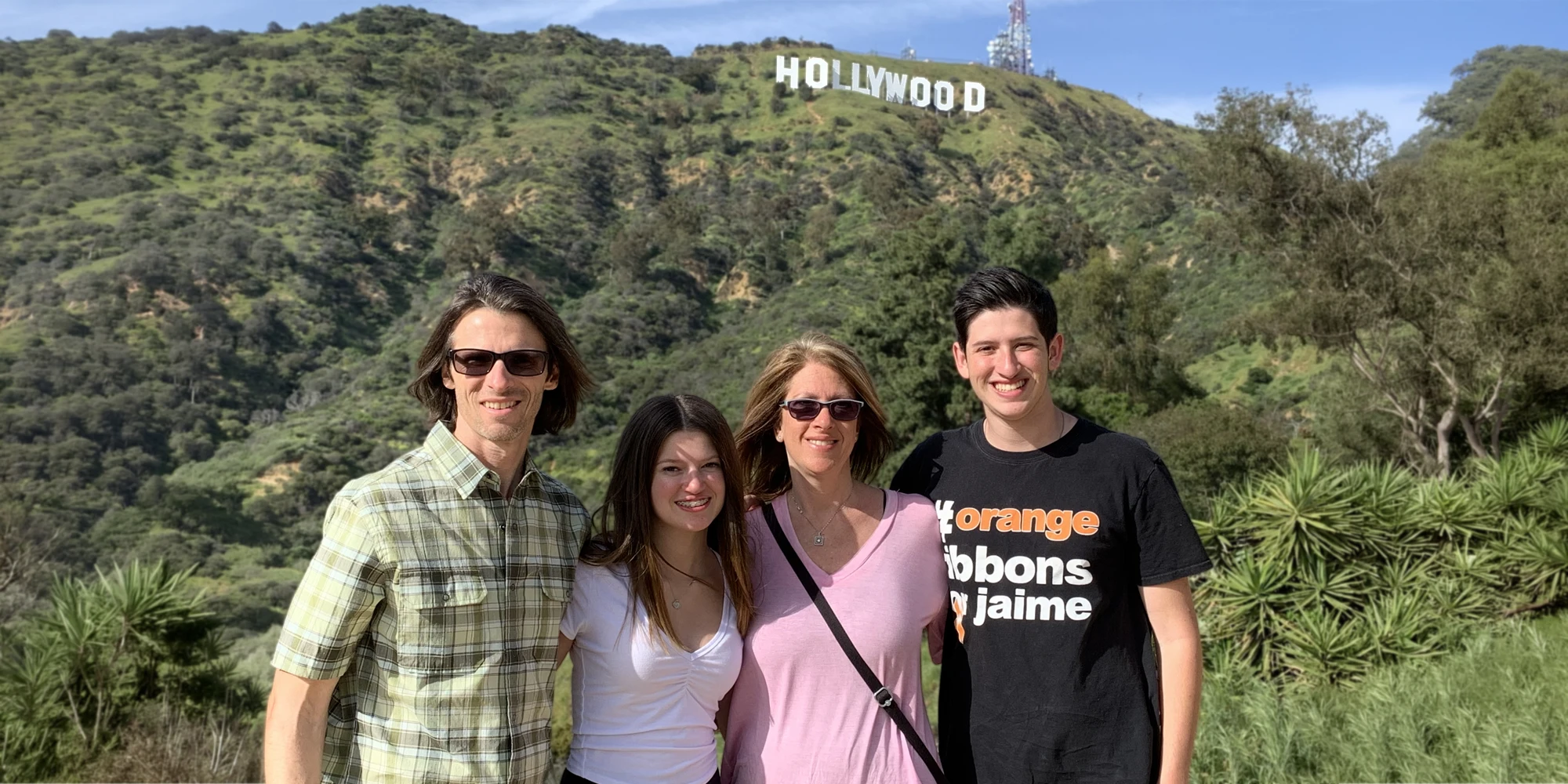 Season Schelin Posing With His Family in Front of the Hollywood Sign